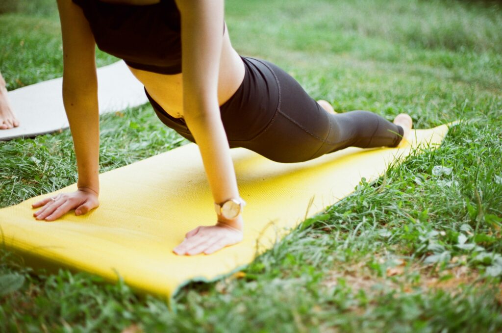 woman-doing-yoga-on-a-mat-outside
